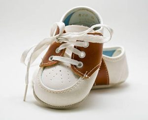 Brown and white saddle shoes for baby on a white background.
